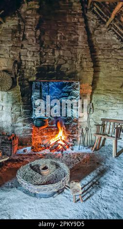 Gusseiserner Kessel über einem offenen Rasenfeuer in einer traditionellen irischen Hütte. Stockfoto