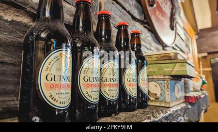 Fünf Flaschen Guinness Original auf einem Regal. Stockfoto