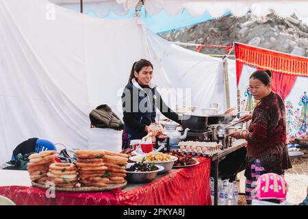 Kathmandu, Nepal - 15. Januar 2023 : Nepali Women Food Seller arrangiert Essen wie: Sel Roti, Fried Fish, Samosa, Momo, Tee etc. Am Imbissstand in Tudikh Stockfoto