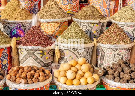 Verschiedene bunte Gewürze in Körben auf den Regalen. Stockfoto
