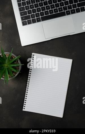 Arbeitsplatz mit leerem Notebook und Laptop auf schwarzem Hintergrund. Draufsicht mit Kopierbereich. Stockfoto
