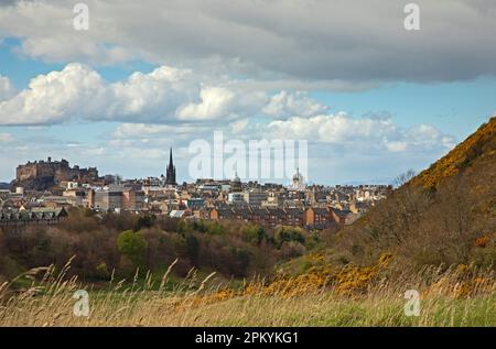 Holyrood Park, Edinburgh, Schottland, Großbritannien. April 2023. Bewölkter heller Nachmittag mit einer scharfen Dusche über der Stadt am Nachmittag, Temperatur ca. 13 Grad Celsius. Im Bild: Blick vom Holyrood Park in Richtung Stadtzentrum und Edinburgh Castle. Stockfoto