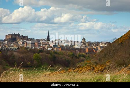 Holyrood Park, Edinburgh, Schottland, Großbritannien. April 2023. Bewölkter heller Nachmittag mit einer scharfen Dusche über der Stadt am Nachmittag, Temperatur ca. 13 Grad Celsius. Im Bild: Blick vom Holyrood Park in Richtung Stadtzentrum und Edinburgh Castle. Stockfoto