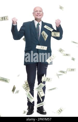 Ein glücklicher Geschäftsmann, der im Regen der Dollarscheine steht. Stockfoto
