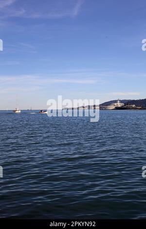 Das Meer und eine Klippe in einer Bucht, die man bei Sonnenuntergang aus der Ferne sieht Stockfoto