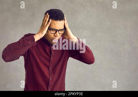 Ein schockierter, emotionaler afroamerikaner, der einen harten Studioschuss abwirft Stockfoto