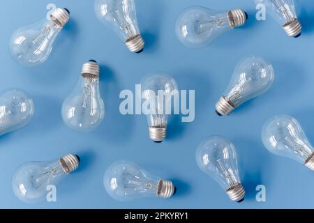 Satz von CFL-Glühbirnen auf blauem Hintergrund, die das Konzept verschiedener Ideen darstellen Stockfoto