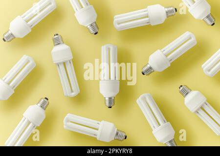 Satz CFL-Glühbirnen auf gelbem Hintergrund, die das Konzept verschiedener Ideen darstellen Stockfoto