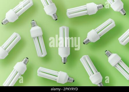 Satz von CFL-Glühbirnen auf grünem Hintergrund, die das Konzept verschiedener Ideen darstellen Stockfoto