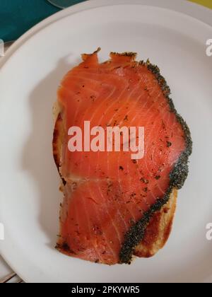 Une tranche de saumon gravelax posée sur un blini maison chaud Stockfoto