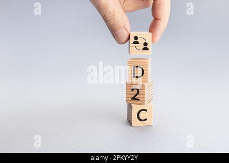 Direct to Customer D2C-Konzept. Hand legt einen Block mit Symbol und Textwort über andere. Speicherplatz kopieren Stockfoto