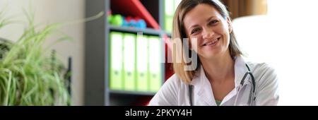 Lächelnde Ärztin posiert im Klinikbüro Stockfoto