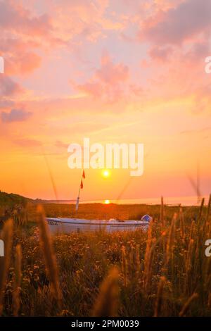 Boot am Strand mit malerischem Sonnenuntergang Stockfoto