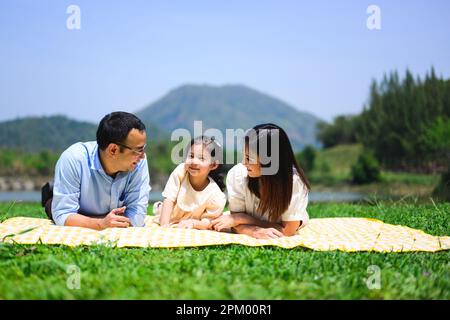 Eine glückliche Familie, die sich am Wochenende im Park entspannen und gemeinsam im Freien spielen kann Stockfoto
