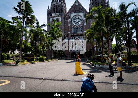 Yangon, Myanmar. 10. April 2023. Jemand lässt sich in einem hellgelben Kleid fotografieren, während er vor St. steht Mary's Cathedral in Rangun. Am 1. Februar 2021 ergriff die Militärjunta-Regierung (Tatmadaw) die Macht durch Putsch, inhaftierte die demokratisch gewählte Regierung der NLD (Nationale Liga für Demokratie) und stürzte das Land in eine anhaltende humanitäre Krise, die von vielen als Bürgerkrieg oder Volksaufstand bezeichnet wird. Kredit: SOPA Images Limited/Alamy Live News Stockfoto