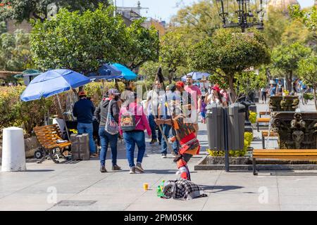 Guadalajara, Jalisco Mexiko. 4. Februar 2023. Landschaft des urbanen Lebens im historischen Stadtzentrum, Menschen zu Fuß, Mann, der einen einheimischen Krieger repräsentiert, fou Stockfoto