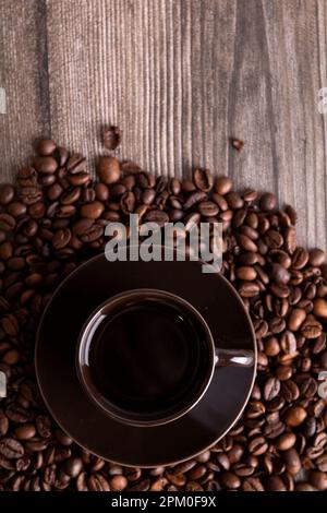 Fotobecher mit Kaffee und Kaffeebohnen, Draufsicht Stockfoto