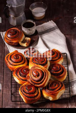 Hefeteig mit Zimt mit Mohnsamen, Rosinen und kandierten Früchten, serviert mit Kaffee. Rustikaler Stil. Stockfoto