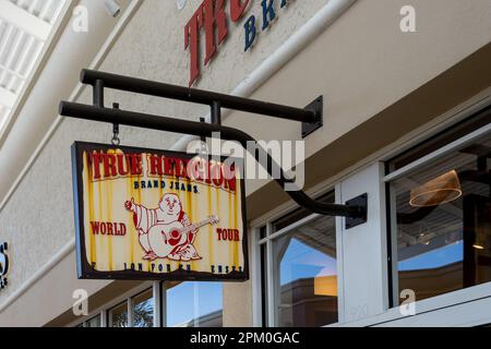 Nahaufnahme des Ladenschilds der True Religion Brand Jeans auf dem Gebäude. Stockfoto