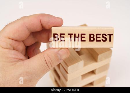 Geschäftskonzept. Ein Mann hält in seinen Händen einen Holzblock mit der Inschrift "Be the Best" Stockfoto