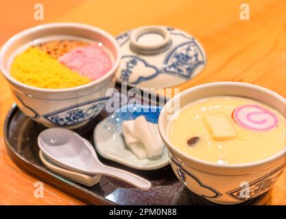 nagasaki, kyushu - 11 2022. dez.: Traditionelle japanische Chawanmushi-Eiercreme mit rosafarbenem Sakura denbu, in kinshi Tamago geschredderten Eiercrepe und Buta Stockfoto