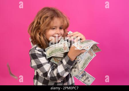 Ein Kind, das viele hundert Dollar isoliert auf rosa rotem Hintergrund hat Stockfoto