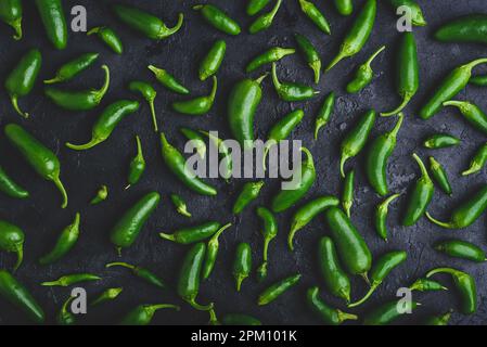 Hintergrund von Raw Green Jalapeno Peppers auf dunkler Betonoberfläche Stockfoto