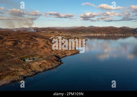 Blick nach Osten in Richtung des kleinen Dorfes Gairloch an der Westküste Schottlands. Das Meer im Bild ist Loch Gairloch. Ein Moorfeuer ist sichtbar. Stockfoto