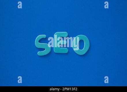 Das Wort SEO aus blauen Buchstaben auf blauem Hintergrund. Blaue Buchstaben als SEO-Abkürzung Search Engine Optimization . Stockfoto