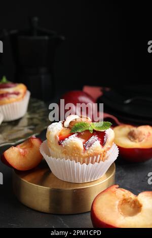 Leckere Cupcakes mit Pflaumen auf schwarzem Tisch, Nahaufnahme Stockfoto