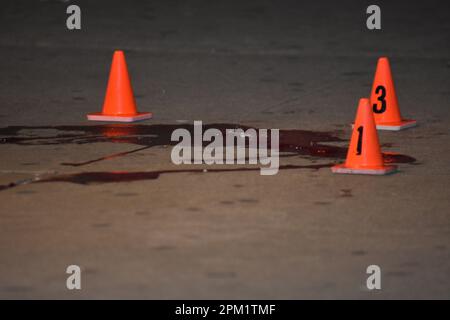 Bronx, Usa. 10. April 2023. (HINWEIS AN DIE REDAKTION: Bild enthält grafischen Inhalt)Blut- und Evidenzmarkierungen am Tatort. Zwei Männer wurden laut New York City Police Department erschossen. Ein 17-jähriger Mann wurde angeschossen und ist in stabilem Zustand, und ein anderer Mann ist in kritischem Zustand. Kredit: SOPA Images Limited/Alamy Live News Stockfoto