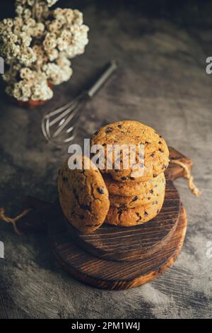 Hausgemachte Schokoladenkekse auf schwarzem Backblech und abstraktem Hintergrund Stockfoto