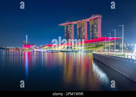 Besondere farbige Lichteffekte beleuchten das Marina Bay Sands Hotel während der abendlichen „Spectra Light and Water Show“ in Marina Bay in Singapur. Stockfoto