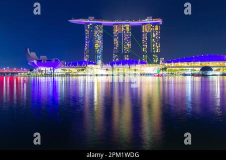 Besondere farbige Lichteffekte beleuchten das Marina Bay Sands Hotel während der abendlichen „Spectra Light and Water Show“ in Marina Bay in Singapur. Stockfoto