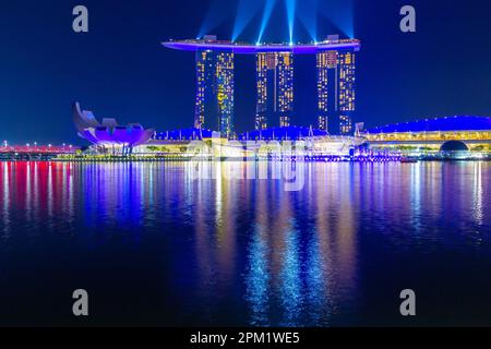 Besondere farbige Lichteffekte beleuchten das Marina Bay Sands Hotel während der abendlichen „Spectra Light and Water Show“ in Marina Bay in Singapur. Stockfoto