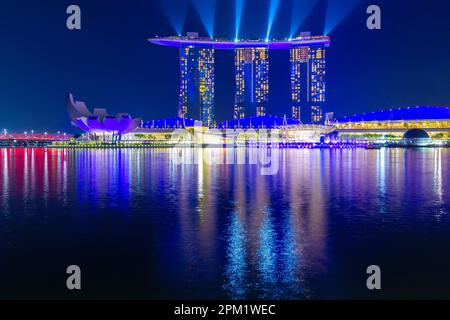 Besondere farbige Lichteffekte beleuchten das Marina Bay Sands Hotel während der abendlichen „Spectra Light and Water Show“ in Marina Bay in Singapur. Stockfoto