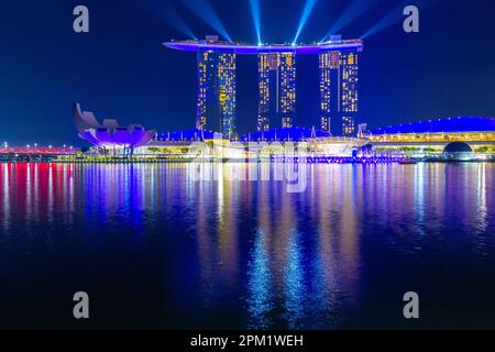 Besondere farbige Lichteffekte beleuchten das Marina Bay Sands Hotel während der abendlichen „Spectra Light and Water Show“ in Marina Bay in Singapur. Stockfoto