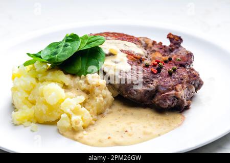 Rindersteak mit Sauce, Kartoffelpüree und Spinatblättern Stockfoto