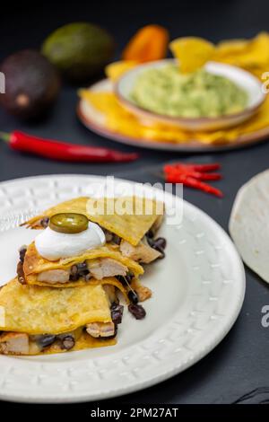 Quesadilla mit Hühnerfleisch und Bohnen und Guacamole mit Nachos Stockfoto