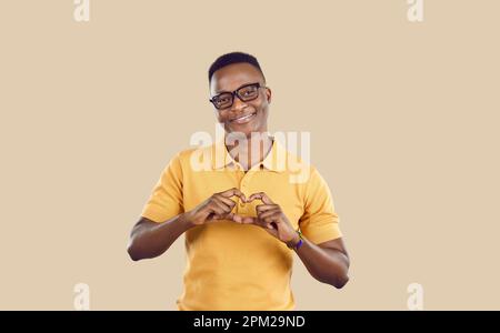 Ein junger afroamerikanischer Mann zeigt ein Herz mit den Fingern als Zeichen einer romantischen Beziehung für seine Freundin Stockfoto