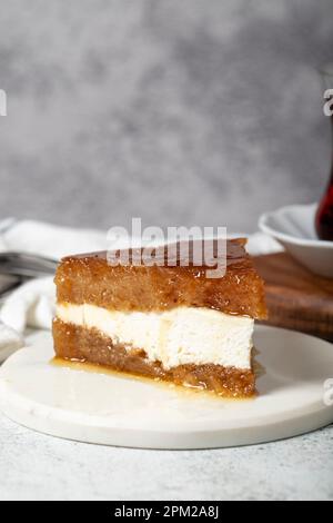 Sherbet-Brot-Kadayif-Dessert. Türkisches Ramadan-Dessert. Brot-Kadayif-Dessert mit Sahne auf einem Servierteller aus Marmor. Lokaler Name Kaymaklı ekmek kadayıfı Stockfoto