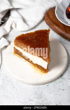 Sherbet-Brot-Kadayif-Dessert. Türkisches Ramadan-Dessert. Brot-Kadayif-Dessert mit Sahne auf einem Servierteller aus Marmor. Lokaler Name Kaymaklı ekmek kadayıfı Stockfoto