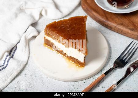 Sherbet-Brot-Kadayif-Dessert. Türkisches Ramadan-Dessert. Brot-Kadayif-Dessert mit Sahne auf einem Servierteller aus Marmor. Lokaler Name Kaymaklı ekmek kadayıfı Stockfoto