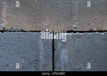 Graue Bausteine aus Zement, gestapelt, Nahhintergrund. Viele große Betonsteine stapeln die Textur Stockfoto