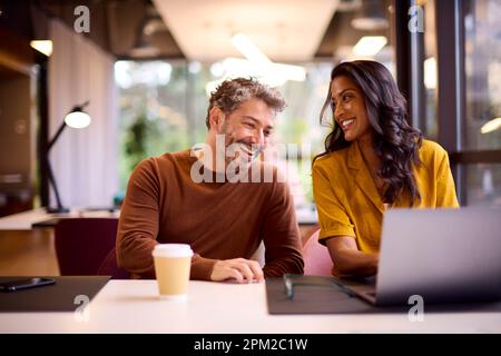 Männliche Und Weibliche Geschäftskollegen Treffen Sich Rund Um Laptop Im Modernen Büro Stockfoto