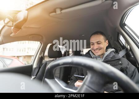 Ein fröhlicher indianer, der Auto fährt, vom Armaturenbrett erschossen wird, während der Sommerferien auf Reisen geht, Kopierraum. Ein glücklicher Typ aus dem Nahen Osten in lässigen Outfits und Stockfoto