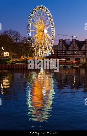 Danzig, Polen - 9. Oktober 2022 - AmberSky Riesenrad auf der Insel Olowianka bei Nacht beleuchtet mit Reflexion im Fluss, wichtigste Touristenattraktion A. Stockfoto