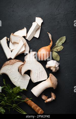 Essbare King Trompeten Pilze noch Leben auf dunklem Hintergrund, Draufsicht Stockfoto