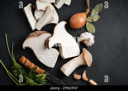 Essbare King Trompeten Pilze noch Leben auf dunklem Hintergrund, Draufsicht Stockfoto
