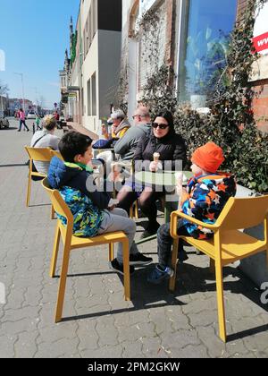 Eine Gruppe von Menschen, die an einem sonnigen Tag in Swiecie, Polen, Eiscreme in einem Café im Freien genießen Stockfoto